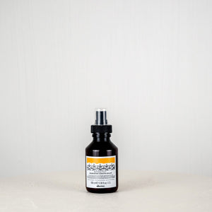 Black bottle with a label on a white surface and light gray background