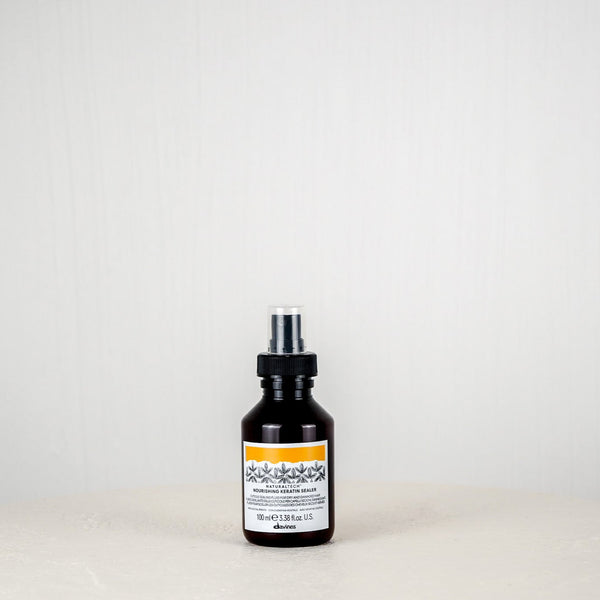 Black bottle with a label on a white surface and light gray background