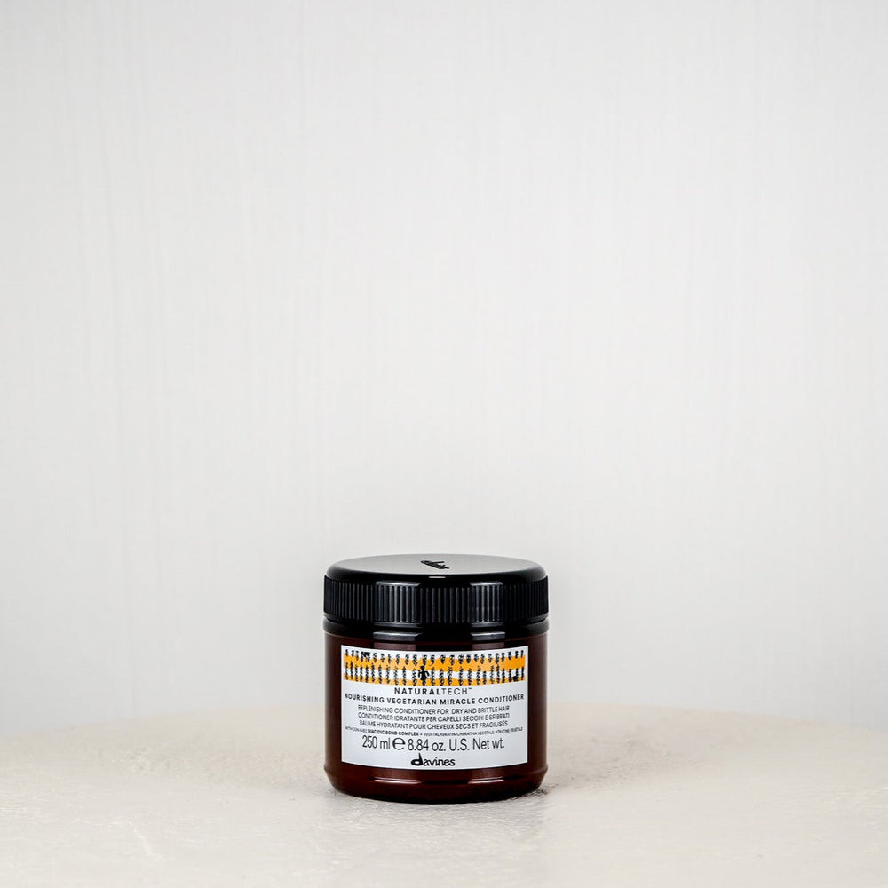 Jar of Davines hair product on a white surface with a white background