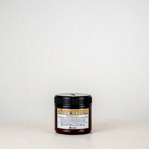 Jar of Davines hair product on a white surface with a white background