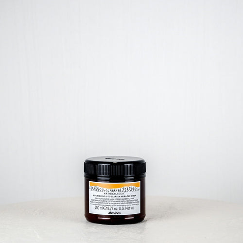 Jar of cream on a white surface with a white background