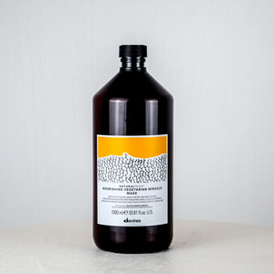 Bottle of Davines hair mask on a white background