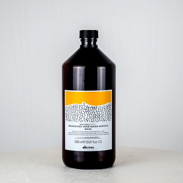 Bottle of Davines hair mask on a white background