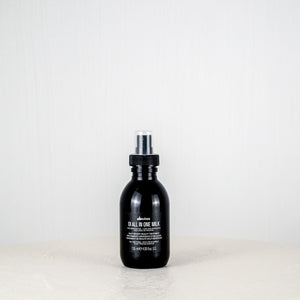 Black bottle of Davines hair product on a white background