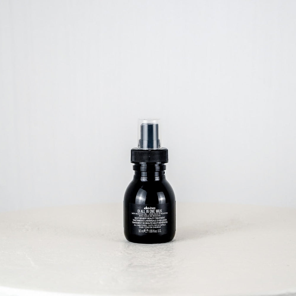 Black bottle of Davines hair product on a white background