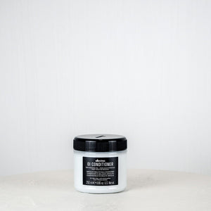 Jar of DANDY conditioner on a white background