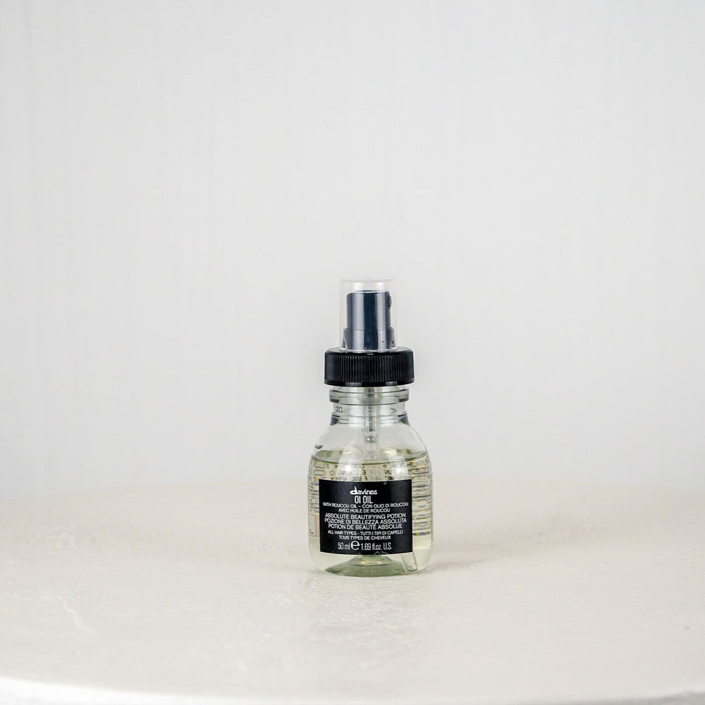 Bottle of Aesop product on a white surface with a white background