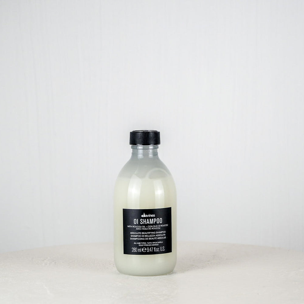 Bottle of Davines shampoo on a white surface with a white background