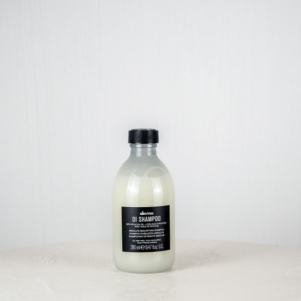 Bottle of Davines shampoo on a white surface with a white background