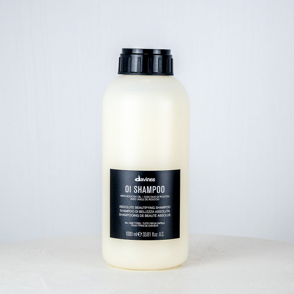 Bottle of Davines shampoo on a white surface with a white background