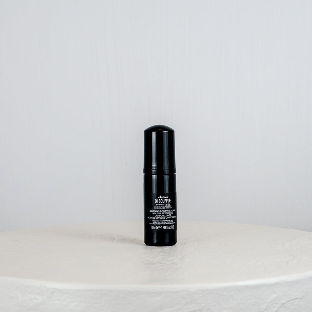 Black bottle with white text on a white surface and background