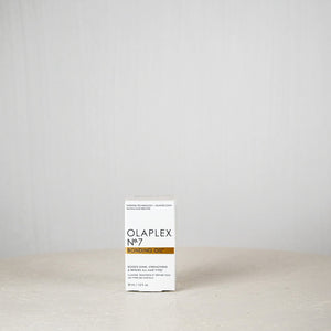Olaplex No.7 product box on a white surface with a light gray background