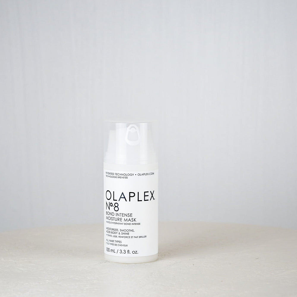 Olaplex bottle on a white surface with a gray background