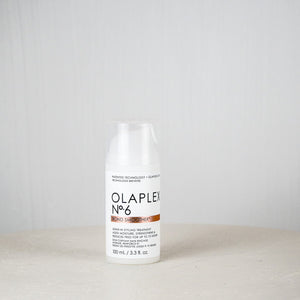 Olaplex bottle on a white surface with a light gray background