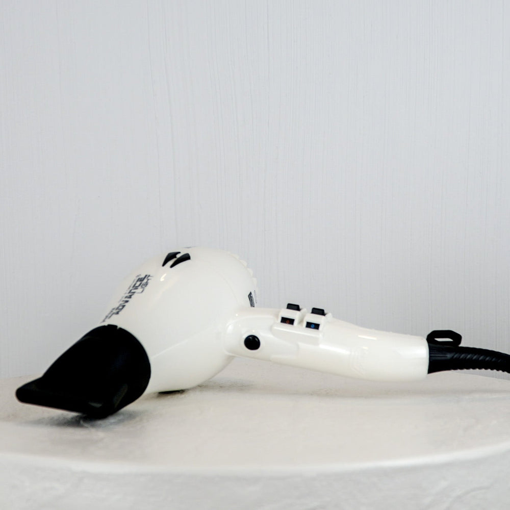 White hair dryer with black accents on a white background