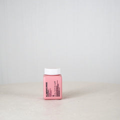 Pink bottle with white cap on a light gray background