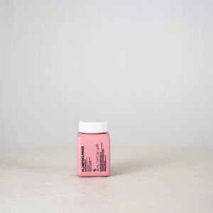 Pink bottle with white cap on a light gray background