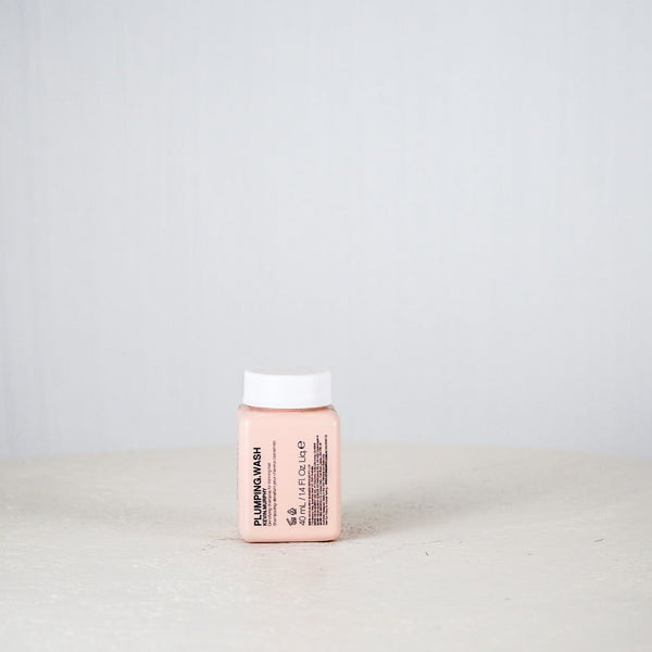 Small pink container with a white cap on a light gray background