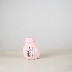 Pink bottle with text on a light gray background