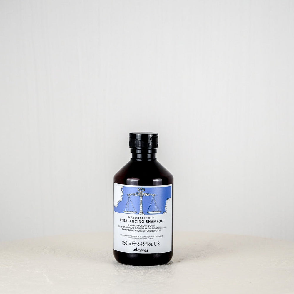 Bottle of Davines Rebalancing Shampoo on a white background