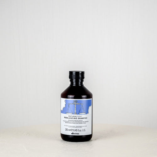 Bottle of Davines Rebalancing Shampoo on a white background