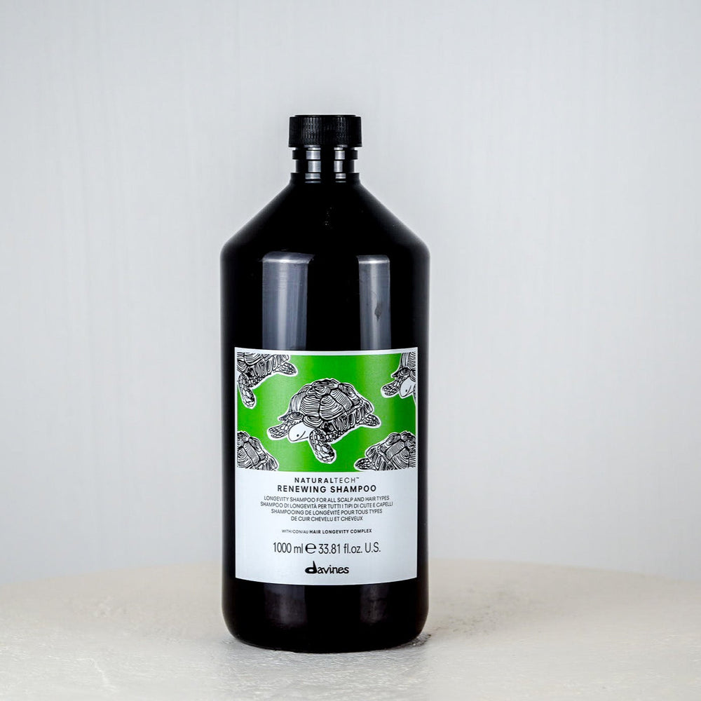 Bottle of Davines shampoo on a white surface with a light gray background