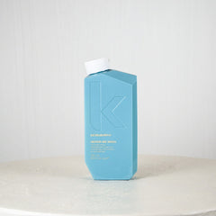 Blue bottle with white cap on a white surface against a light gray background