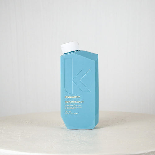 Blue bottle with white cap on a white surface against a light gray background