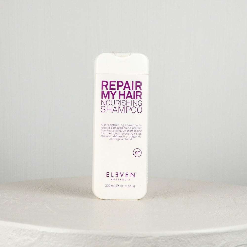 Shampoo bottle labeled 'Repair My Hair Nourishing Shampoo' by 'Eleven Australia' on a white background