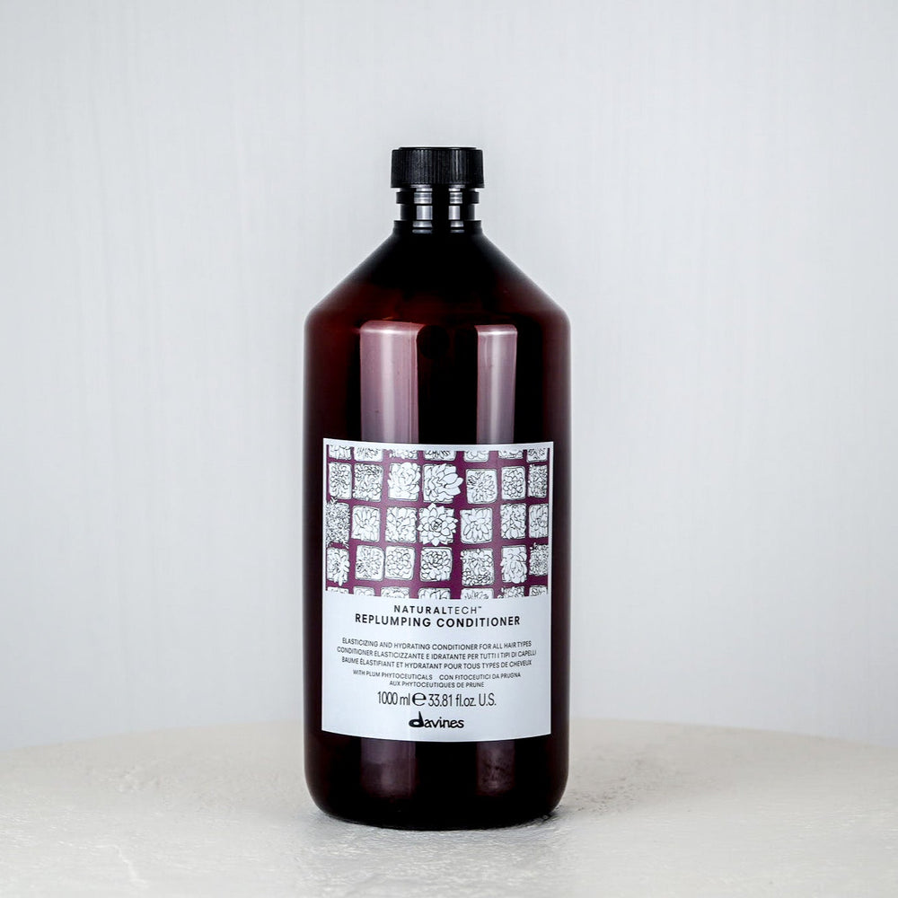 Tube of shampoo or conditioner with a white label on a white surface and light gray background