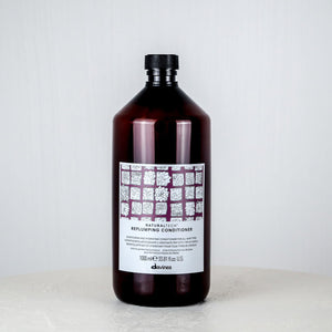 Bottle of conditioner on a white surface with a light gray background