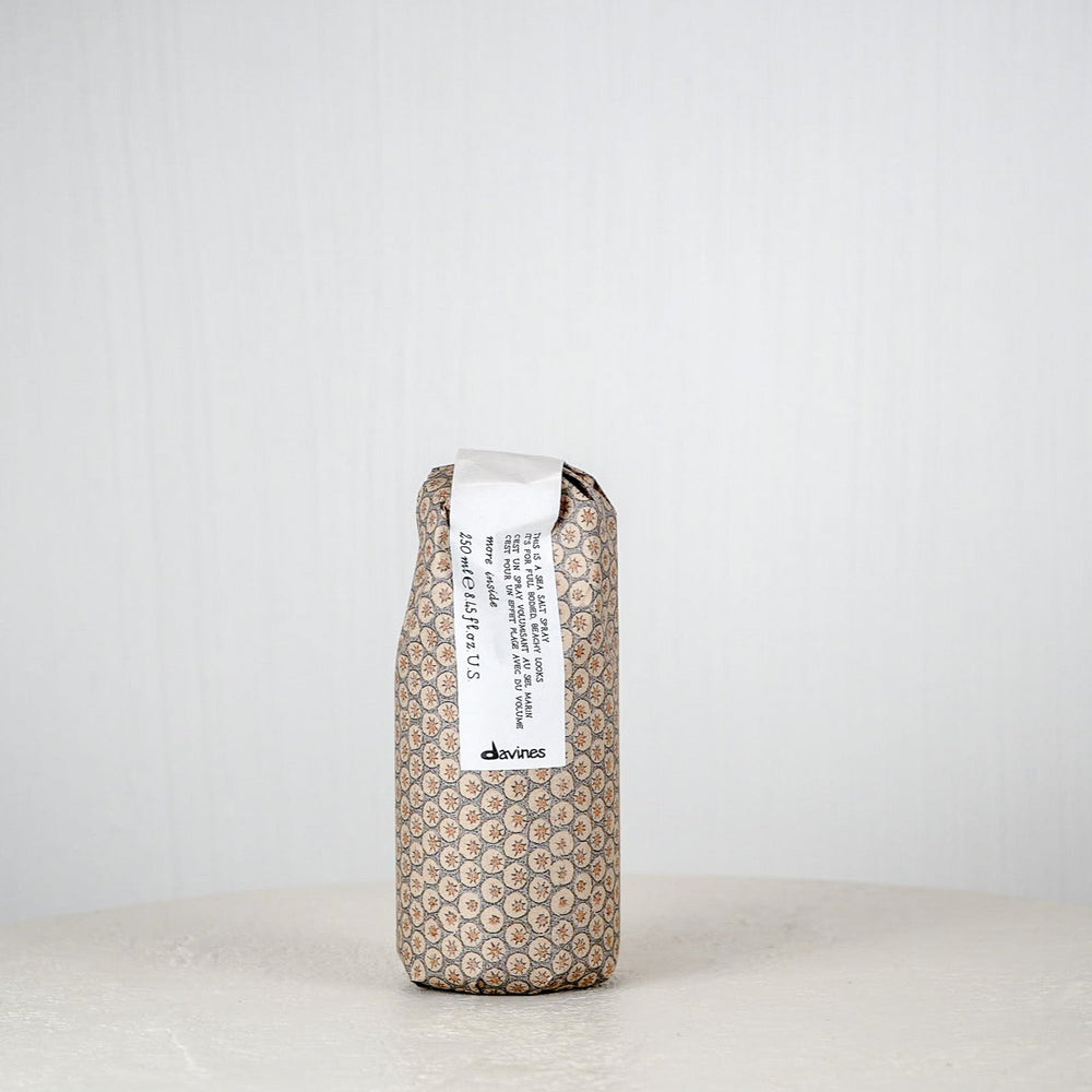 Brown textured package with a white label on a white surface against a light gray background