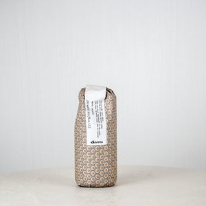 Brown textured package with a white label on a white surface against a light gray background