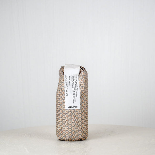 Brown textured package with a white label on a white surface against a light gray background