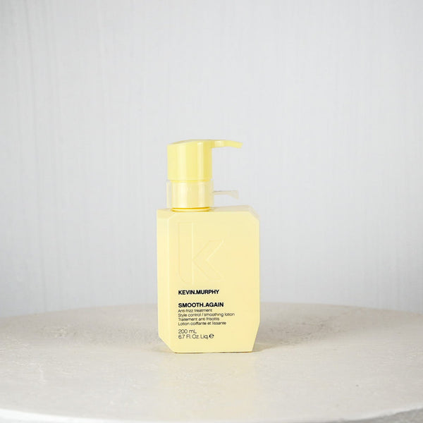 Yellow bottle of Kevin Murphy hair product on a white surface with a light gray background