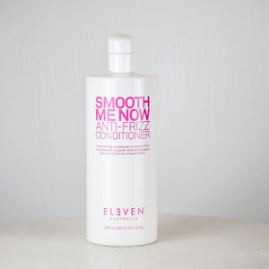 Bottle of 'Smooth Me Now Anti-Frizz Conditioner' by Eleven on a white surface with a gray background
