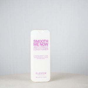 Bottle of 'Smooth Menow' conditioner on a white surface with a gray background