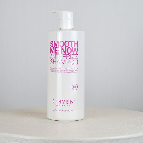 Bottle of Eliven Smooth Me Now Anti-Frizz Shampoo on a white surface with a gray background