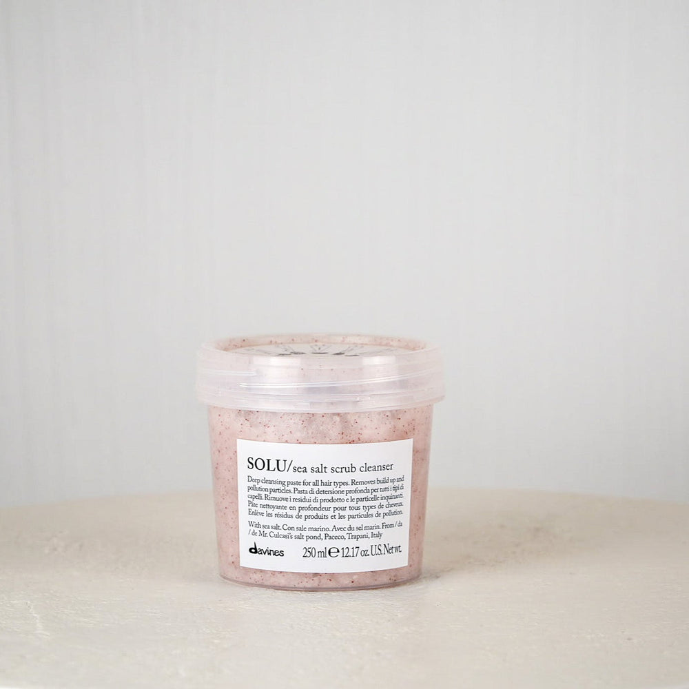 Jar of Davines SOLU rose salt scrub cleanser on a white surface with a light gray background