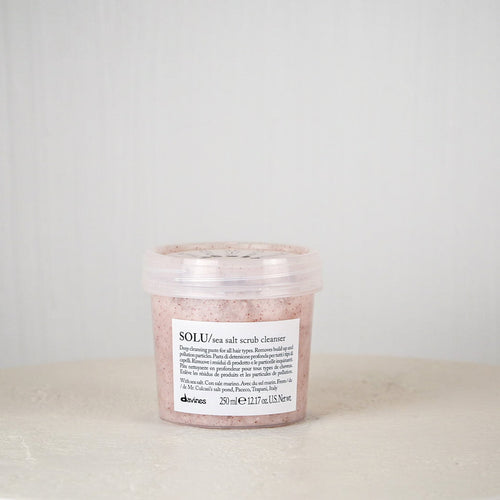 Jar of Davines SOLU rose salt scrub cleanser on a white surface with a light gray background