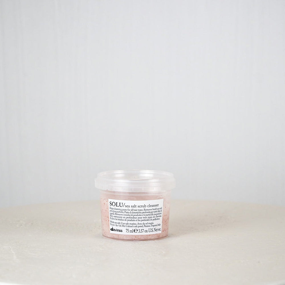 Jar of Davines SOLU rose salt scrub cleanser on a white surface with a light gray background