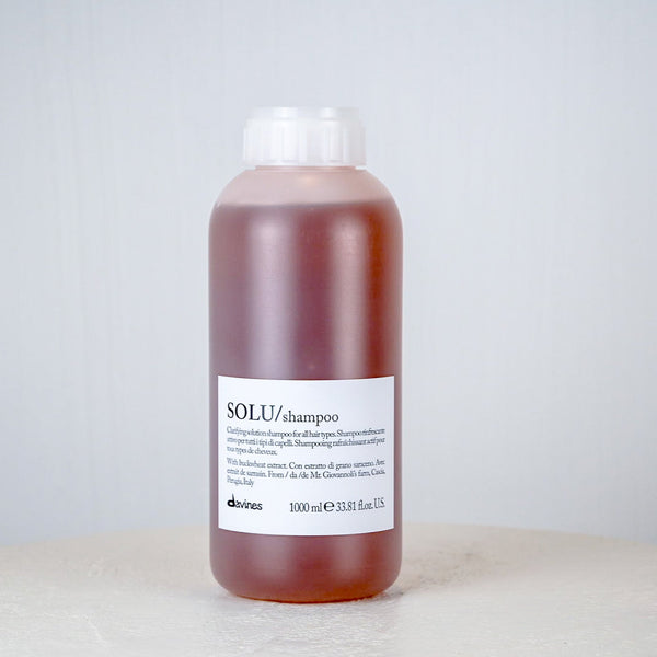Bottle of Davines SOLU shampoo on a light background