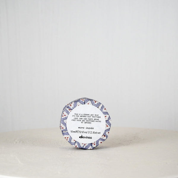 Round container with a decorative label on a white surface