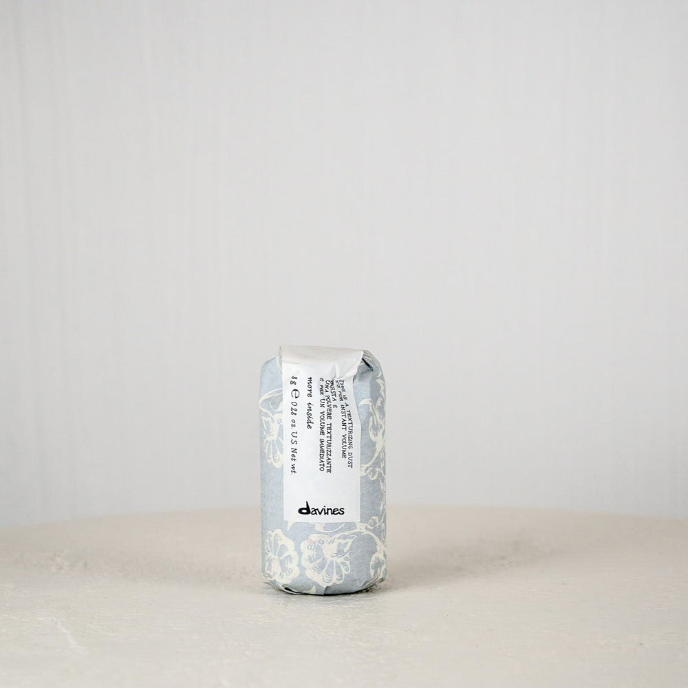 Davines hair product can on a white surface with a light gray background