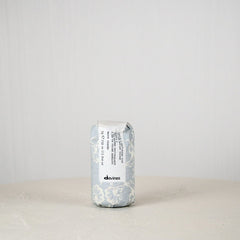 Davines hair product can on a white surface with a light gray background