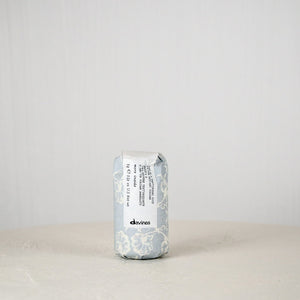 Davines hair product can on a white surface with a light gray background