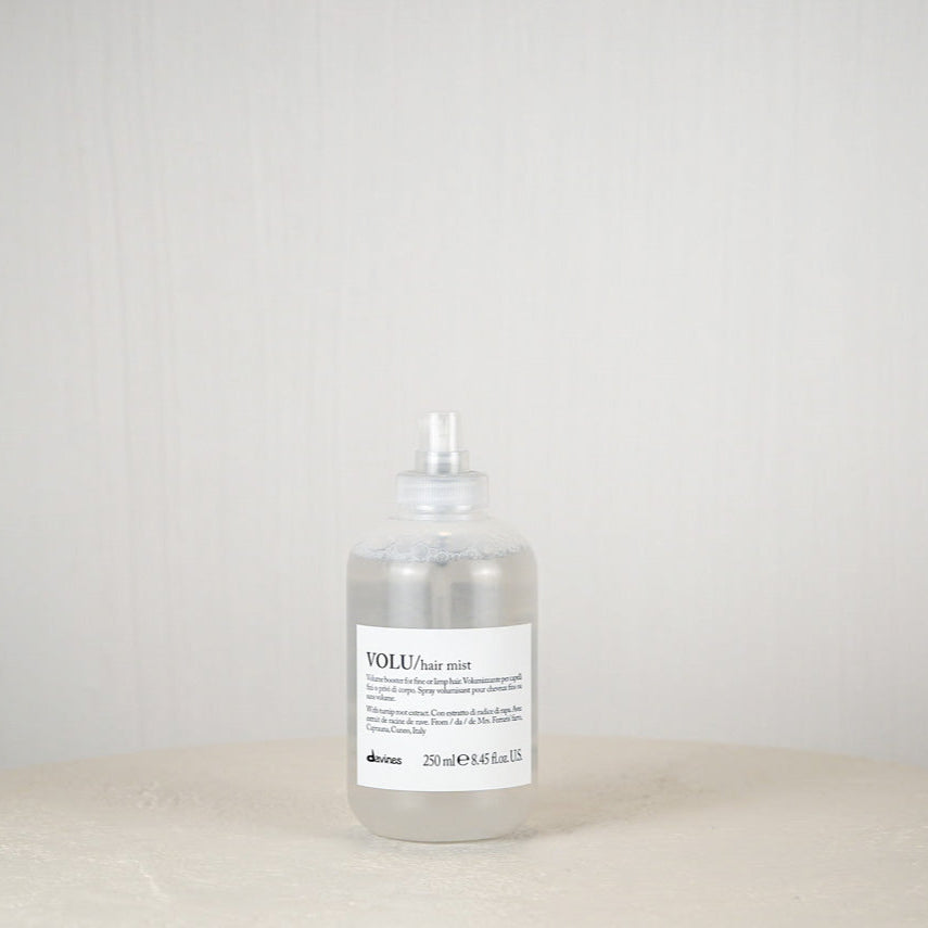 Bottle of Davines hair product on a white surface with a plain background