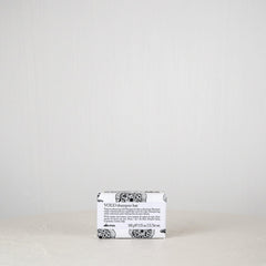 Bar of soap with a white label on a light gray background