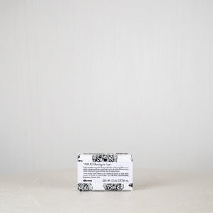 Bar of soap with a white label on a light gray background