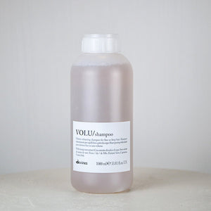 Bottle of Davines VOLU shampoo on a white background